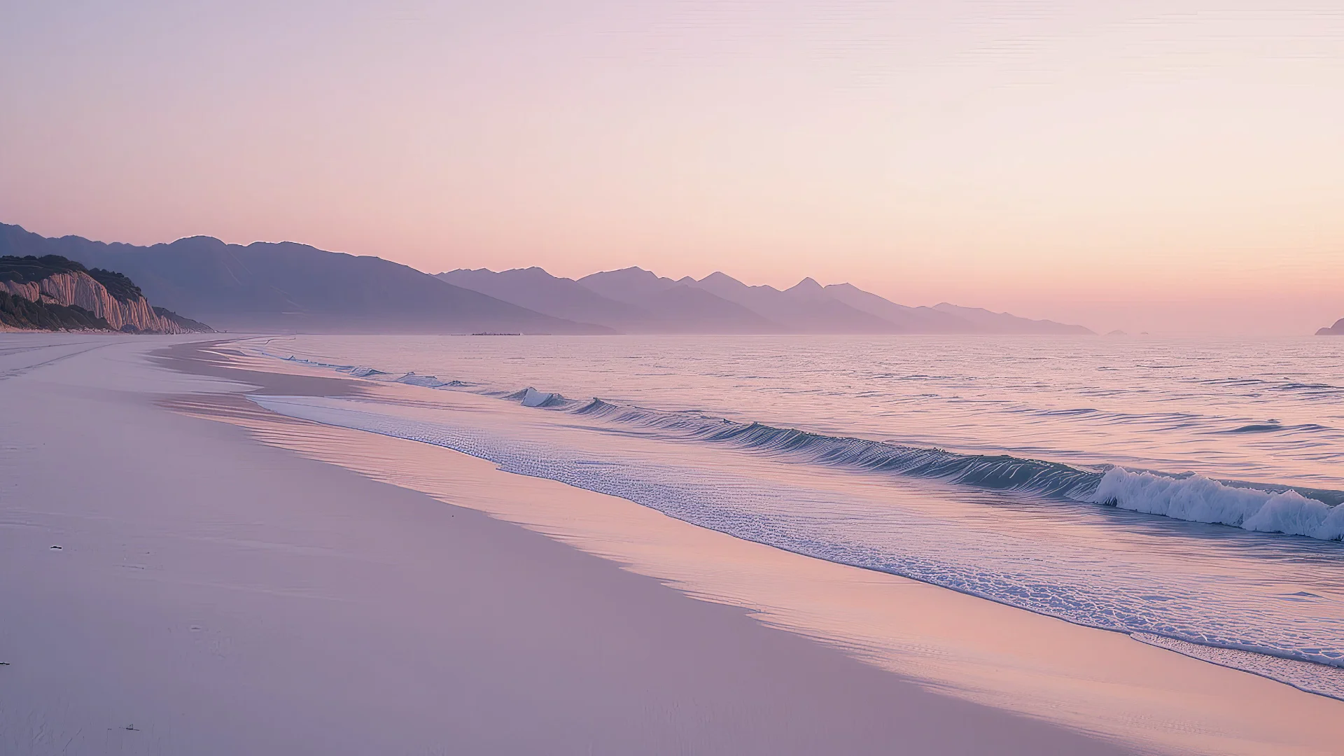 Plage calme au lever du soleil avec vagues et montagnes à l’horizon