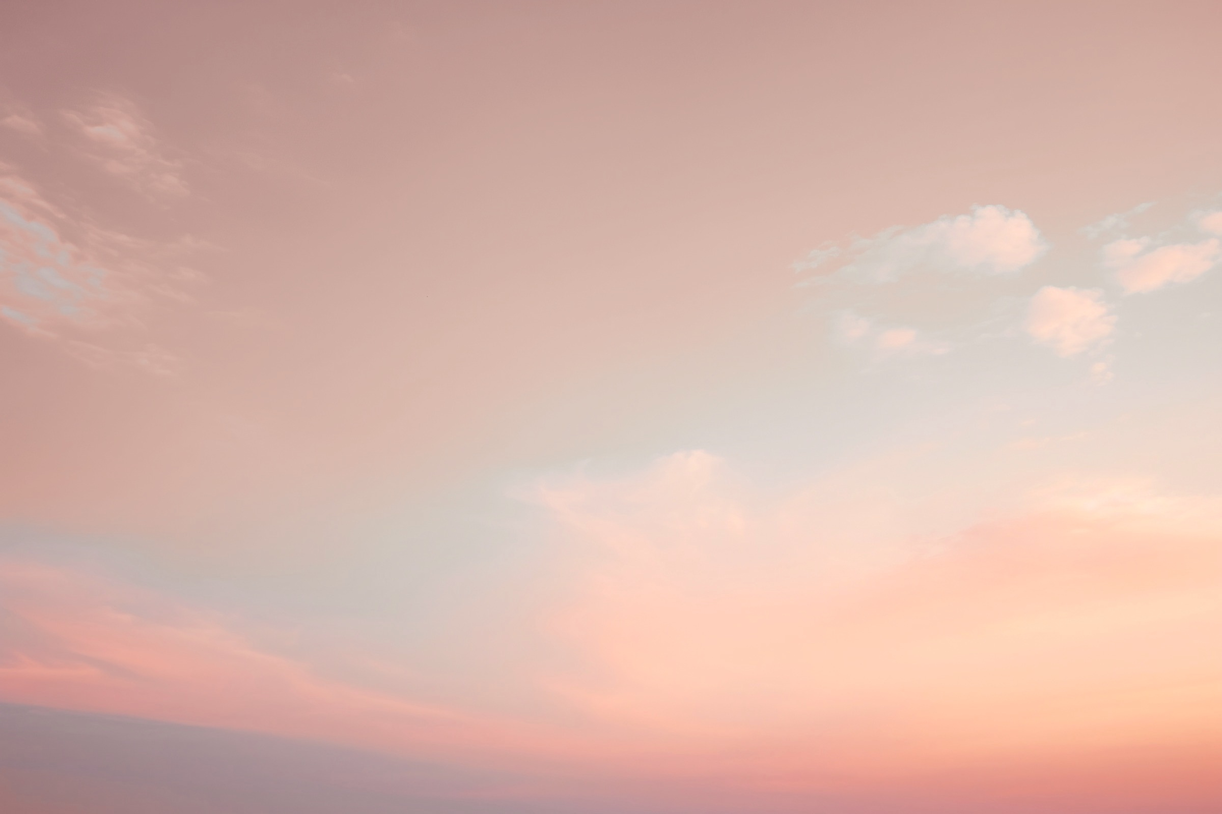 Ciel pastel rose et pêche parsemé de nuages