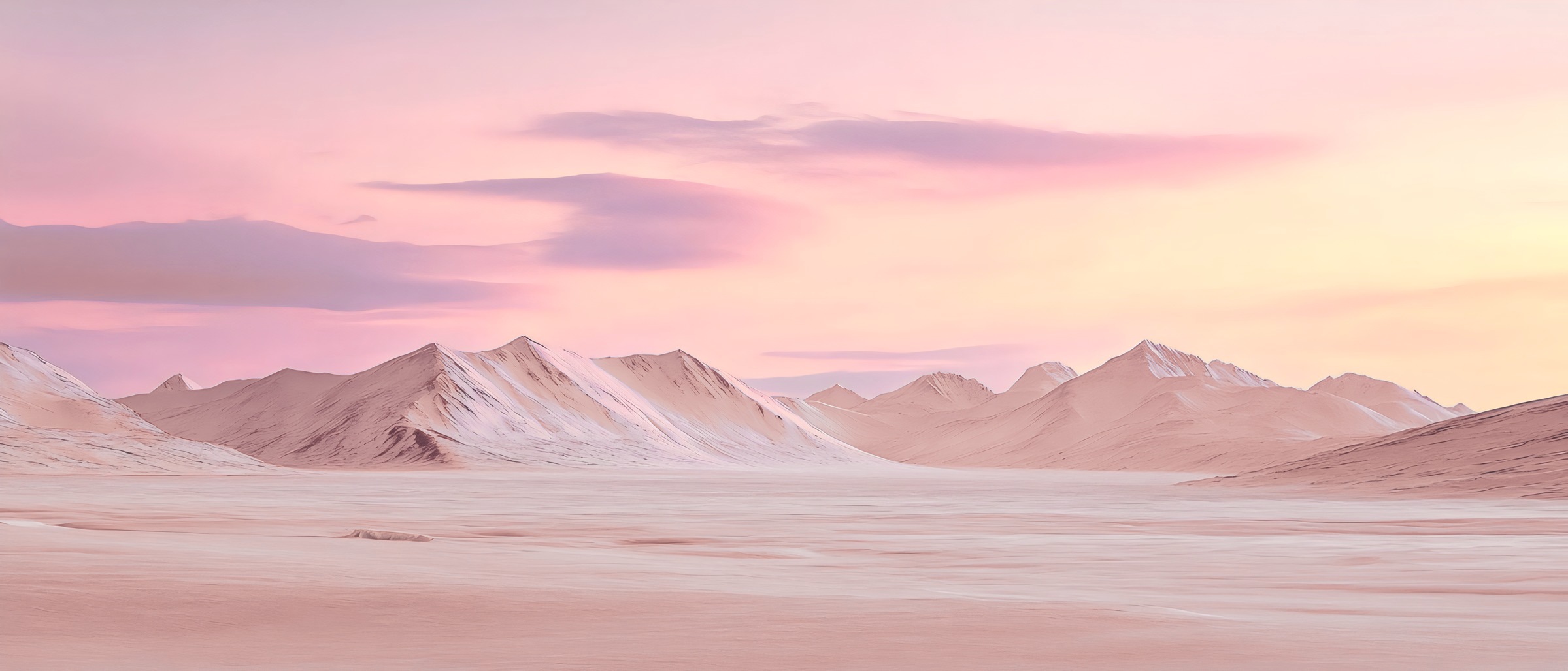 Chaîne de montagnes enneigées sous un ciel rose et doré